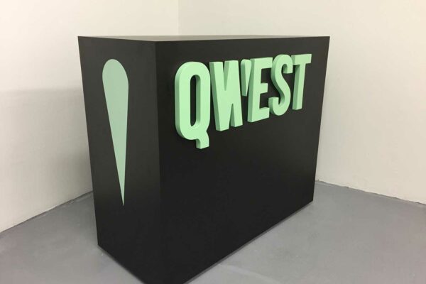Green dimensional lettering on the front of a black kiosk